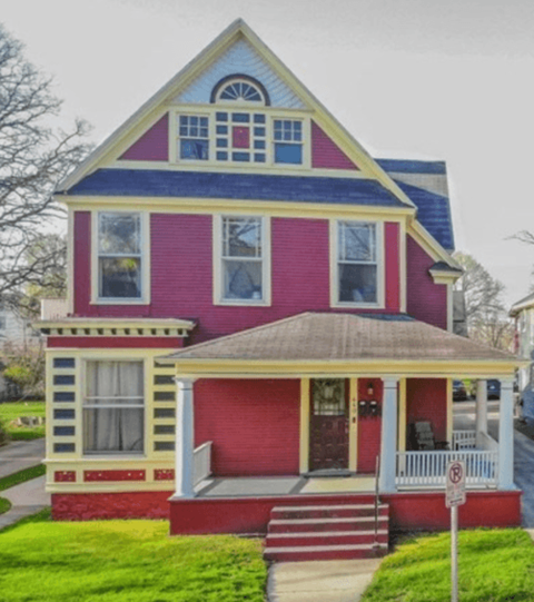 a red house with yellow trim and a blue roof